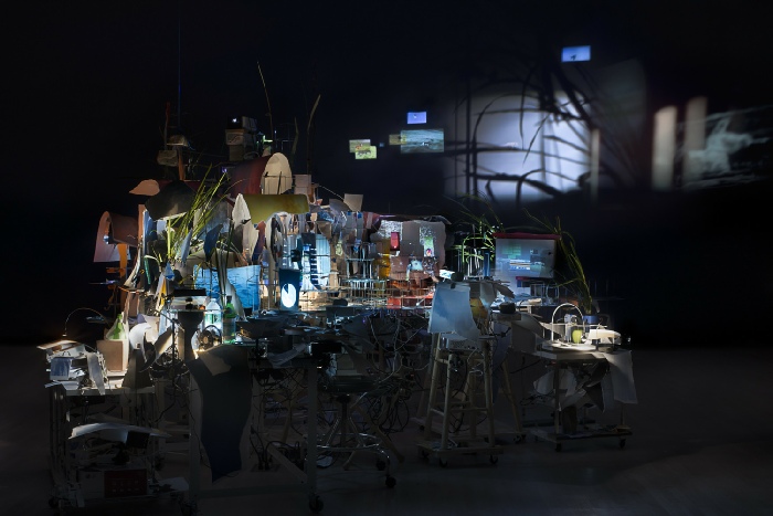 Sarah Sze, Timekeeper, 2016. Mixed media, mirrors, wood, stainless steel, archival pigment prints, projectors, lamps, desks, stools, stone, dimensions variable. Courtesy of the artist, Tanya Bonakdar Gallery, and Victoria Miro Gallery. © Sarah Sze.